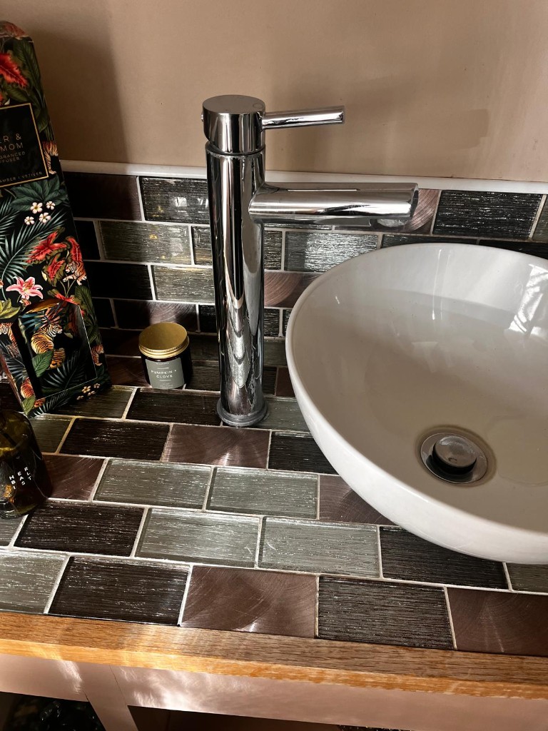 Chrome tap and vessel basin on mosaic tiled bathroom vanity