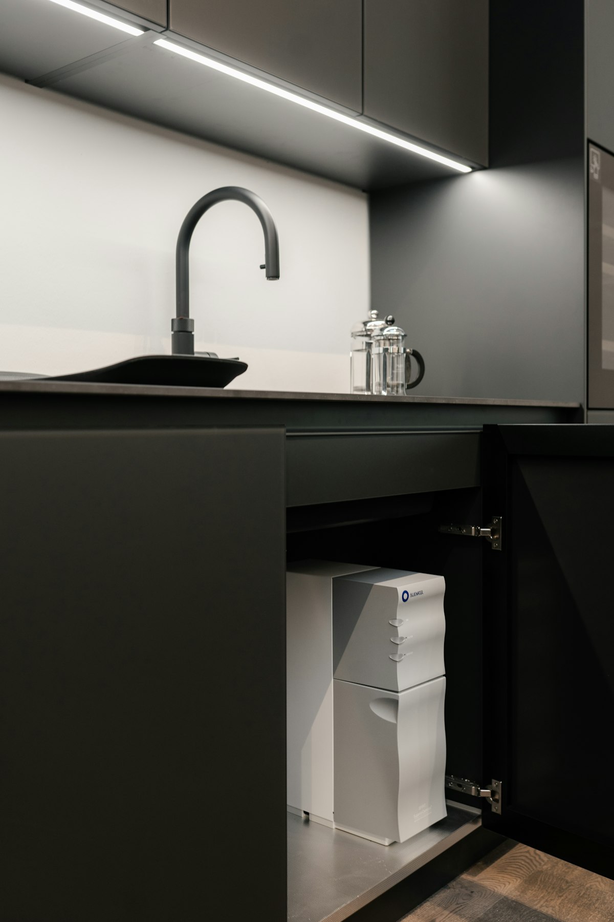 Water softener unit installed under a kitchen sink